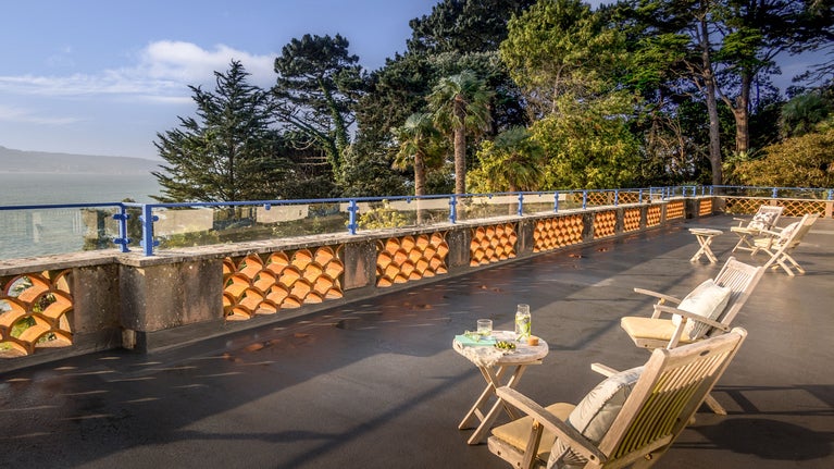 The upper terrace at Portland House, with outdoor furniture, overlooking the harbour, Dorset